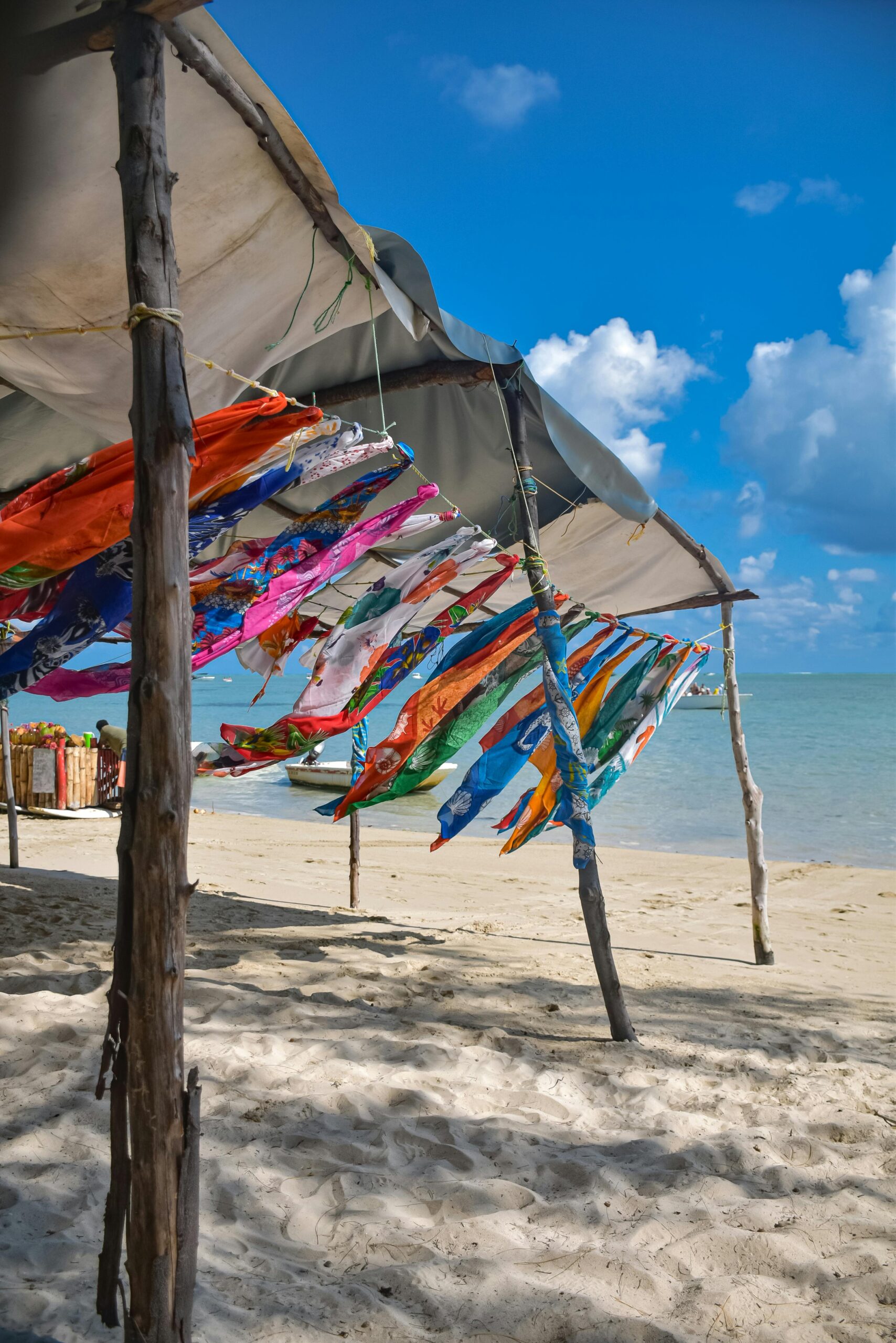 Tkaniny w jaskrawych kolorach powiewają pod baldachimem na piaszczystym wybrzeżu Le Morne na Mauritiusie.