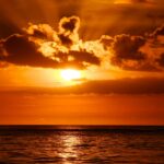 Egzotyczne ogrody i parki Mauritiusa Urzekający zachód słońca nad oceanem z żywymi pomarańczowymi odcieniami i dramatycznymi formacjami chmur.