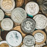 Historia Mauritiusa – od kolonii do niezależności Szczegółowe zbliżenie kolekcji międzynarodowych monet przedstawiających różne waluty.