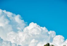 Parasailing i loty nad laguną Mauritiusa Oszałamiający widok na plażę w Flic en Flac na Mauritiusie z palmami i malowniczymi górami.