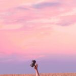 Ciekawostki o kulturze Mauritiusa Nie do poznania dłoń trzymająca aparat na tle pięknego różowego nieba o zmierzchu na trawiastym polu, La Réunion.