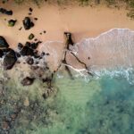 Oszałamiający widok z lotu ptaka na piaszczystą plażę z drewnem wyrzuconym na brzeg i turkusowymi wodami na Mauritiusie.