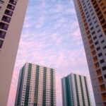 Mauritius dla rodzin z dziećmi – najlepsze atrakcje Wysokie budynki mieszkalne z tętniącym życiem zachodem słońca tworzą nowoczesny architektoniczny pejzaż miejski.