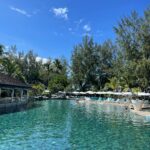 Języki na Mauritiusie – kreolski, angielski i francuski Odkryj spokojną atmosferę przy basenie w tropikalnym kurorcie z bujną zielenią i czystym, błękitnym niebem.