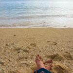 Stopy na piaszczystej plaży z delikatnymi falami na Mauritiusie w dzielnicy Plaines Wilhems.