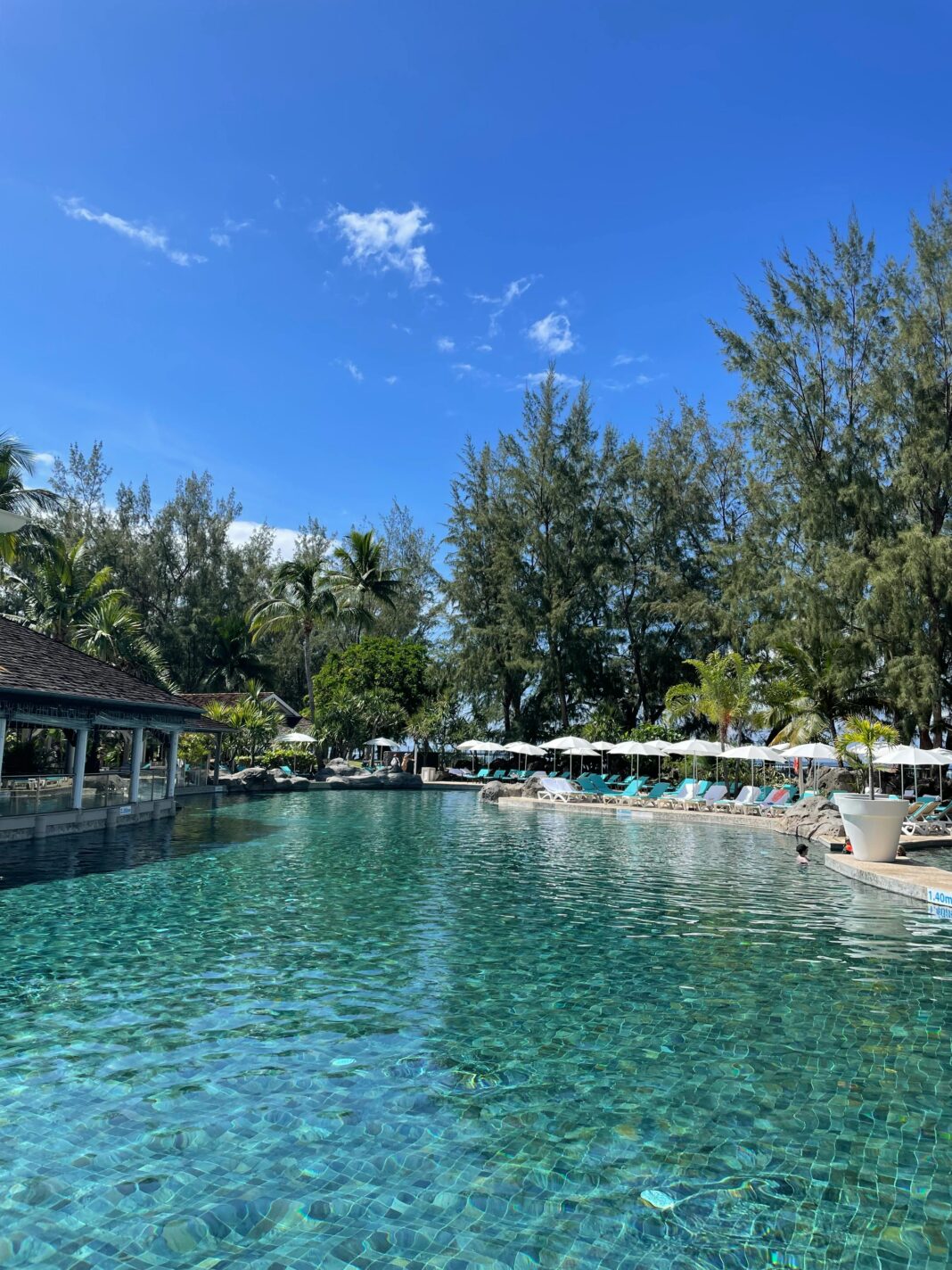 mauritius Odkryj spokojną atmosferę przy basenie w tropikalnym kurorcie z bujną zielenią i czystym, błękitnym niebem.