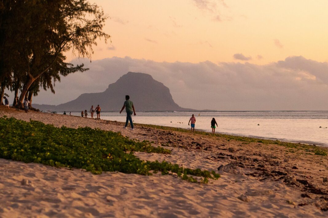 Przeżyj spokojny zachód słońca na plaży Flic en Flac na Mauritiusie z Le Morne Brabant w tle.