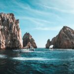 Oszałamiający krajobraz morski Cabo San Lucas z formacjami skalnymi i łodziami w pogodny dzień.