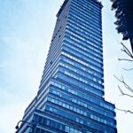 Uderzający widok z niskiego kąta na szklany wieżowiec w Meksyku pod czystym niebem.