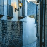 Odkryj malowniczą meksykańską aleję z brukowanymi uliczkami i rustykalną architekturą, pięknie oświetloną o zmierzchu.