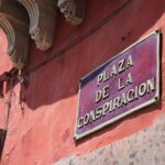Żywa czerwona ściana ze znakiem Plaza de la Conspiración w San Miguel de Allende w Meksyku.