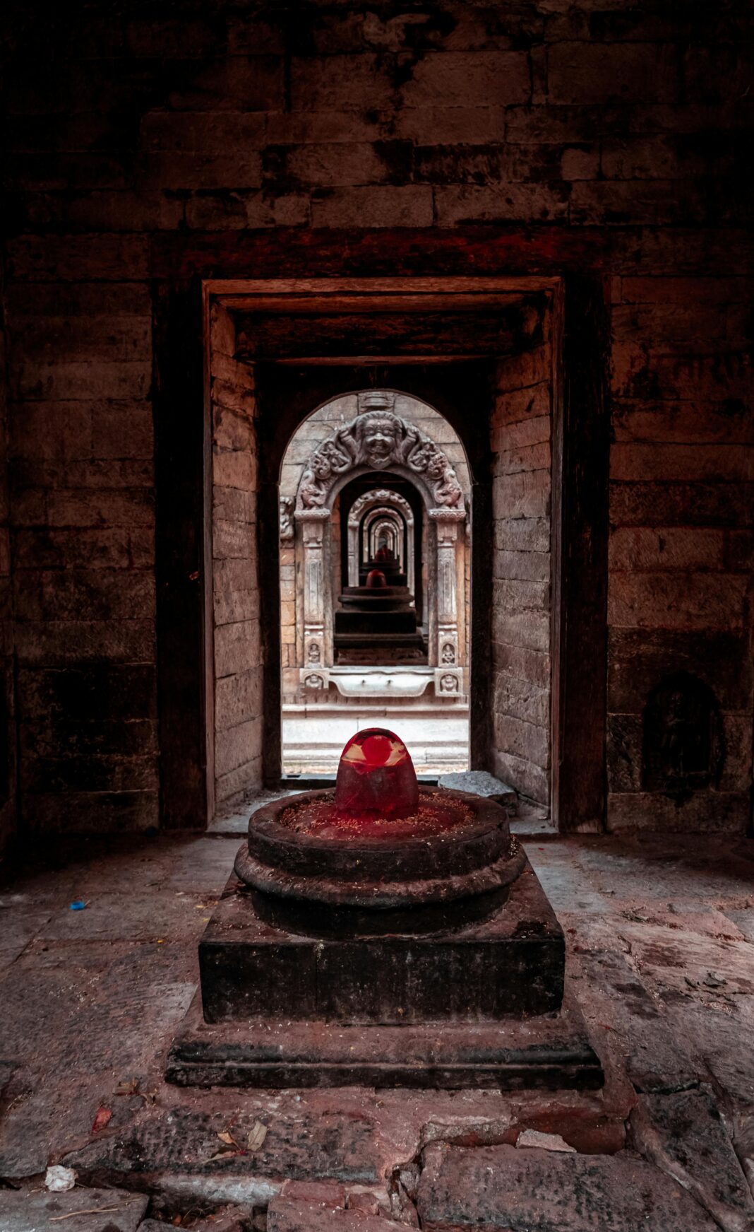 Historyczna świątynia w Nepalu z szeregiem kamiennych łuków i świętym lingamem.