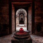 Historyczna świątynia w Nepalu z szeregiem kamiennych łuków i świętym lingamem.