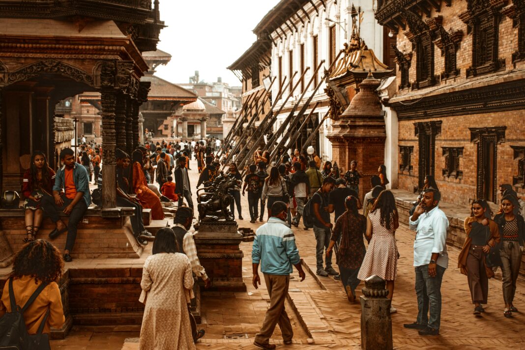 Tętniąca życiem scena uliczna w Katmandu w Nepalu, prezentująca historyczną architekturę i różnorodny tłum.