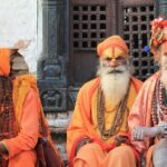 Trzej sadhu w tradycyjnych strojach w świątyni Pashupatinath w Nepalu, będący przykładem tętniącego życiem dziedzictwa kulturowego.