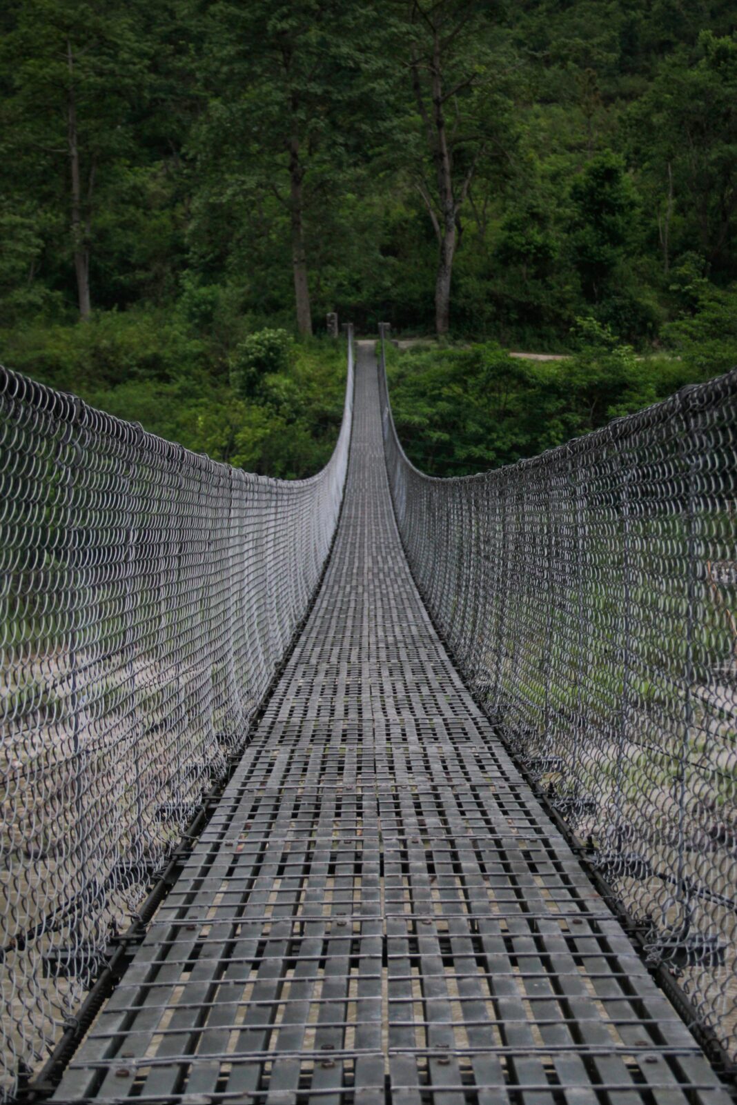 Most wiszący w bujnym nepalskim lesie oferujący ścieżkę pełną przygód.