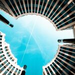 Niski kąt widzenia nowoczesnych okrągłych budynków na tle jasnego błękitnego nieba w Berlinie.