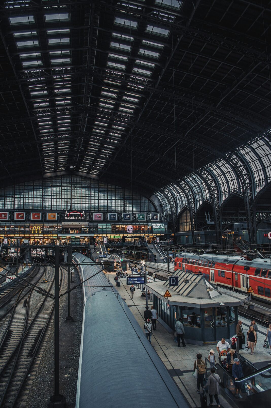 niemcy Aktywny widok na Hamburg Hauptbahnhof przedstawiający podróżnych i pociągi na kultowym niemieckim dworcu kolejowym.
