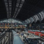 Aktywny widok na Hamburg Hauptbahnhof przedstawiający podróżnych i pociągi na kultowym niemieckim dworcu kolejowym.