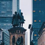 Posągi w centrum Frankfurtu otoczone nowoczesnymi drapaczami chmur. 