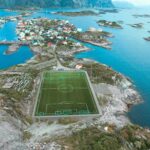 Tradycyjne potrawy Norwegii – TOP 10 dań Zapierający dech w piersiach widok z lotu ptaka na boisko do piłki nożnej na Lofotach, Vågan, Norwegia, w otoczeniu oszałamiającego krajobrazu morskiego i gór.