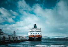 Tradycje i święta w Norwegii Statek płynie po lodowatych wodach portu Finnsnes w Norwegii.