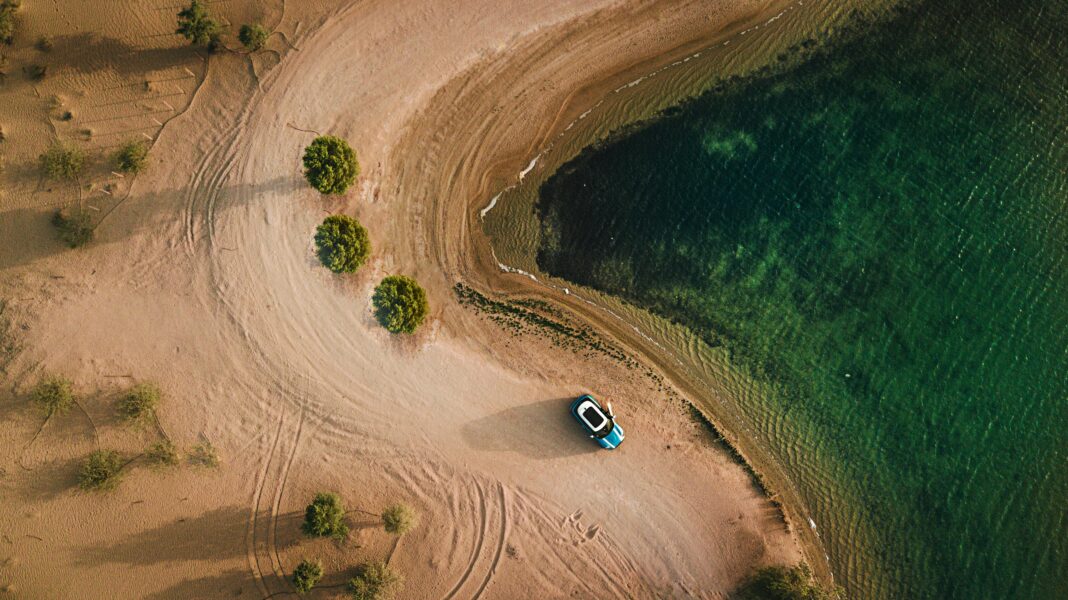 podroz Zdjęcia lotnicze piaszczystej plaży, wody i zaparkowanego samochodu w Dubaju.