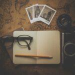 City break w Amsterdamie – co zobaczyć w 48 godzin? Płaski układ niezbędnych artykułów podróżnych, w tym aparatu, notatnika, okularów i mapy do planowania przygód.