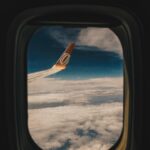 Najlepsze europejskie metropolie na krótki wyjazd Widok na chmury i skrzydło samolotu z miejsca przy oknie, zapewniający spokojną podróż.