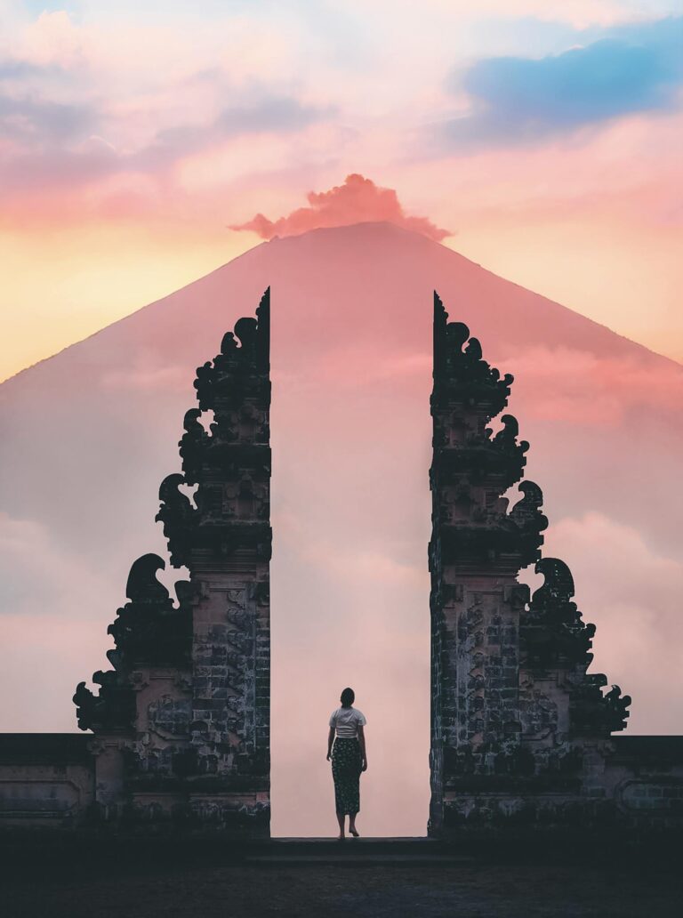Spokojny widok wschodu słońca na osobę stojącą przy bramie świątyni Lempuyang, Bali, Indonezja.