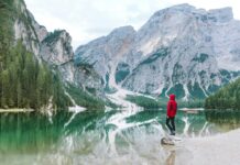 Fakty i mity o Korei Południowej Osoba stojąca nad malowniczym jeziorem Braies z majestatycznymi górami Dolomitów odbitymi w wodzie.