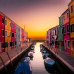 Fakty i mity o podróżach do Indii Żywe fasady wzdłuż kanału Burano z łodziami o spokojnym zachodzie słońca.