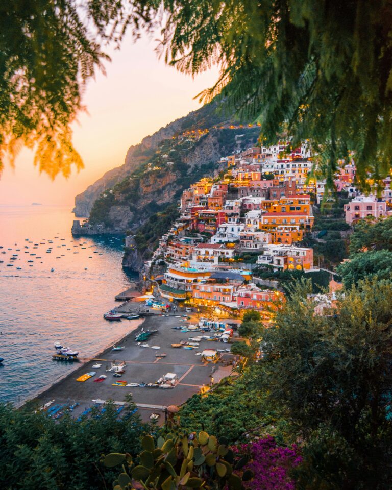 Zapierający dech w piersiach widok na kolorowe domy na klifie Positano o zachodzie słońca.