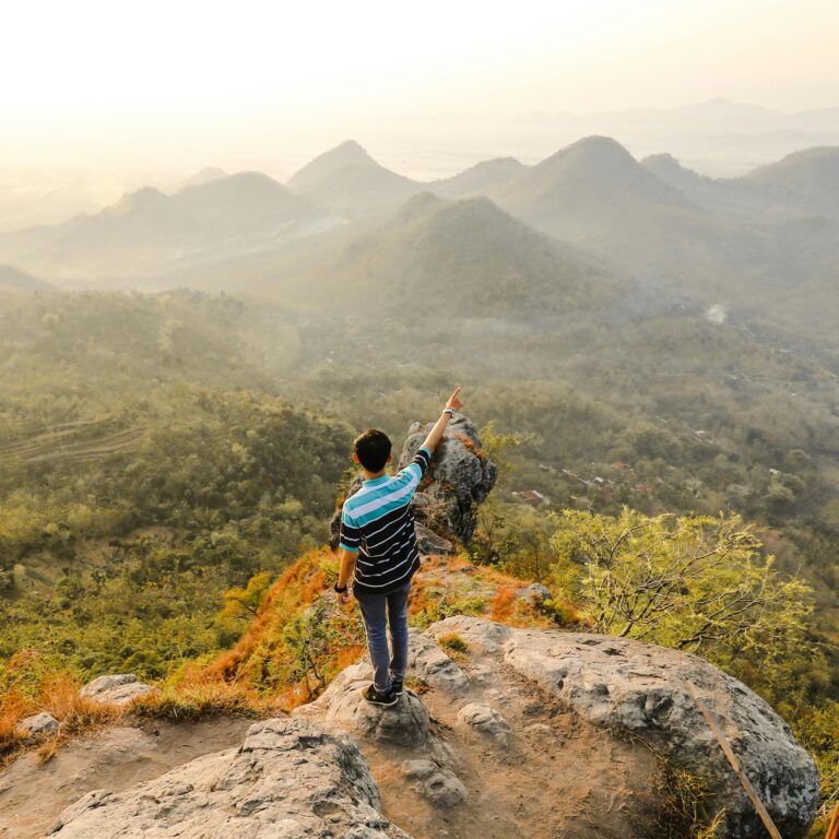 Mężczyzna wskazujący na malownicze góry Mandau Talawang, środkowy Kalimantan, Indonezja.