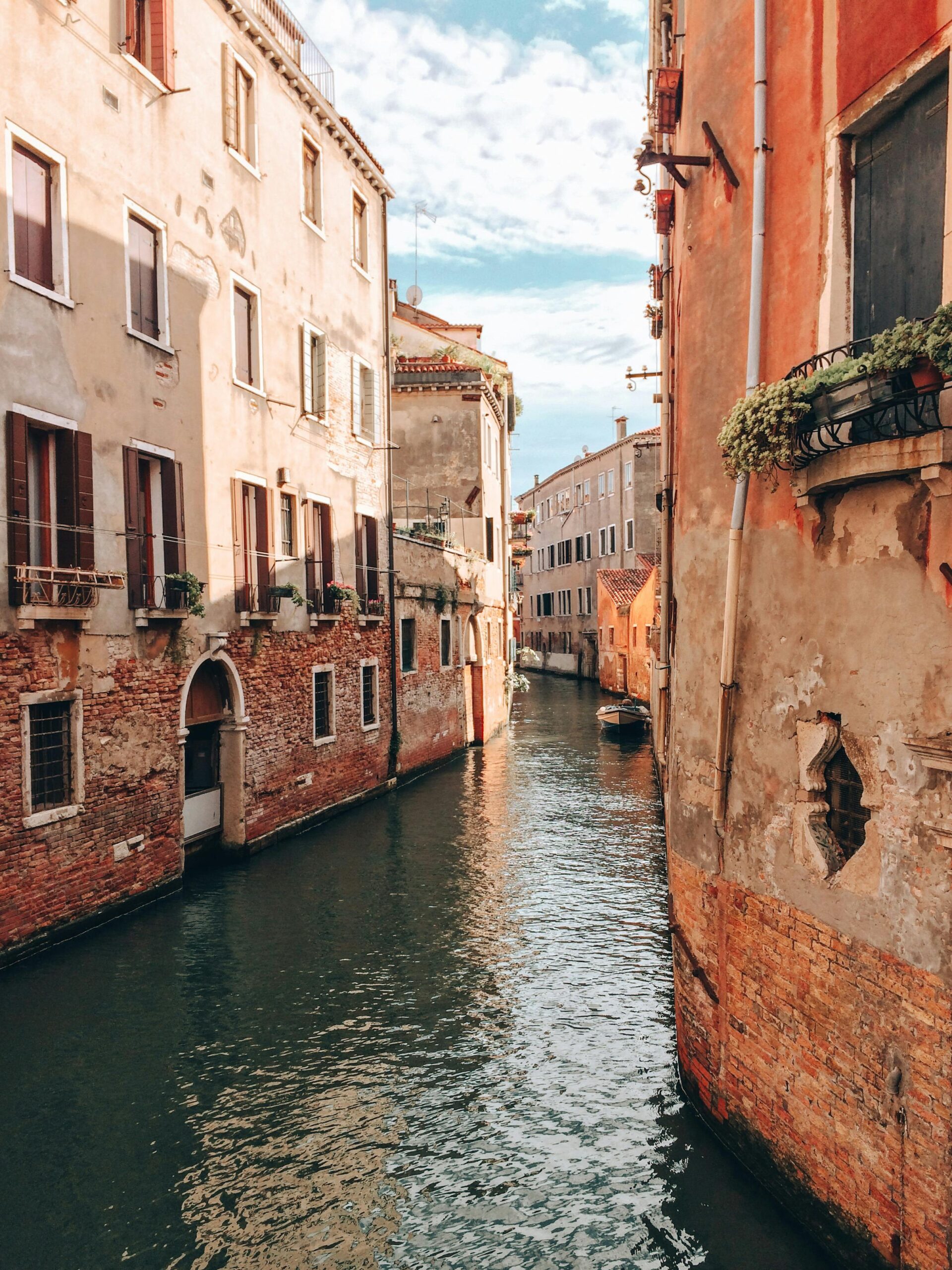 Spokojna powierzchnia wąskiego kanału wśród starych domów z ceglanymi ścianami położonymi na starym mieście