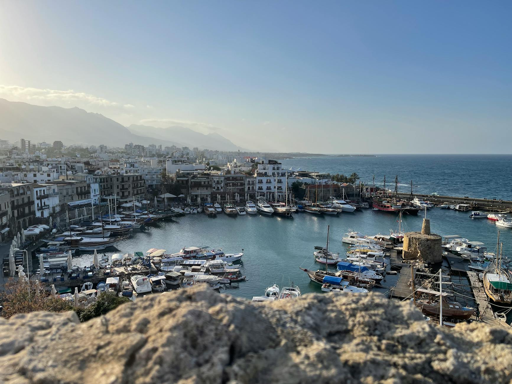Port Kyrenia na Cyprze z zacumowanymi łodziami i zabudowaniami w tle