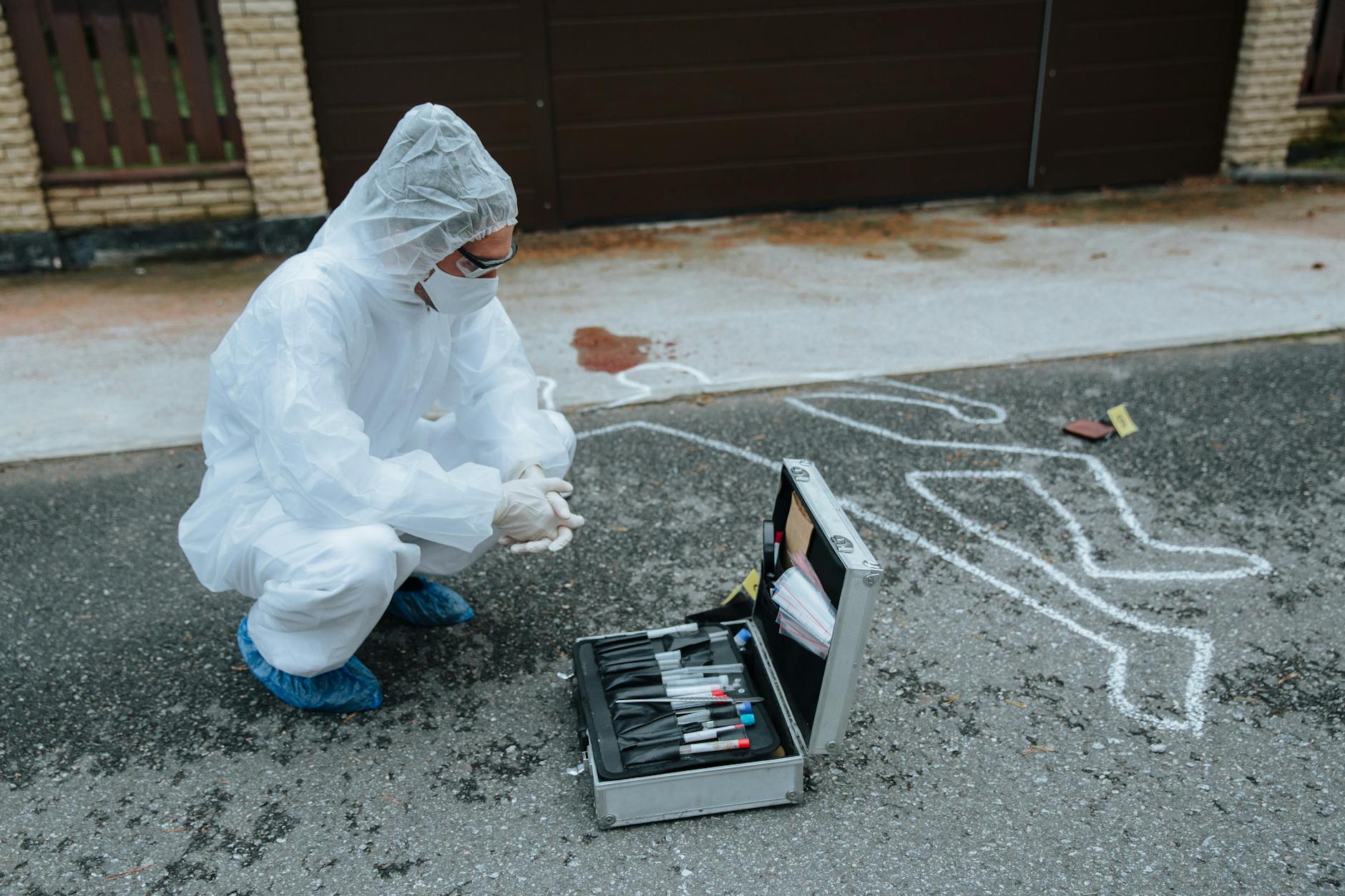 Technik CSI w kombinezonie bada miejsce zbrodni na zewnątrz