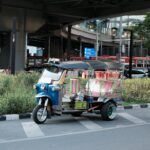 Tuk tuk na ruchliwej ulicy Bangkoku wśród miejskiego zgiełku