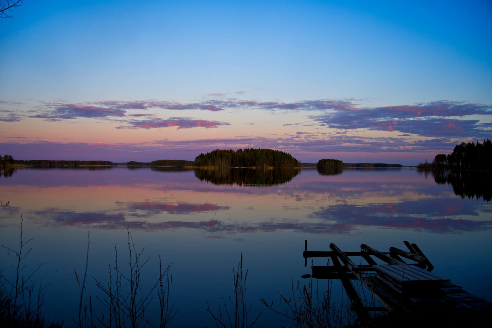 Drewniany pomost nad jeziorem Evijärvi o zmierzchu w Finlandii