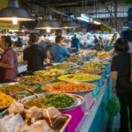 Kolorowe stragany z tajskim street foodem na gwarnym targu w Bangkoku