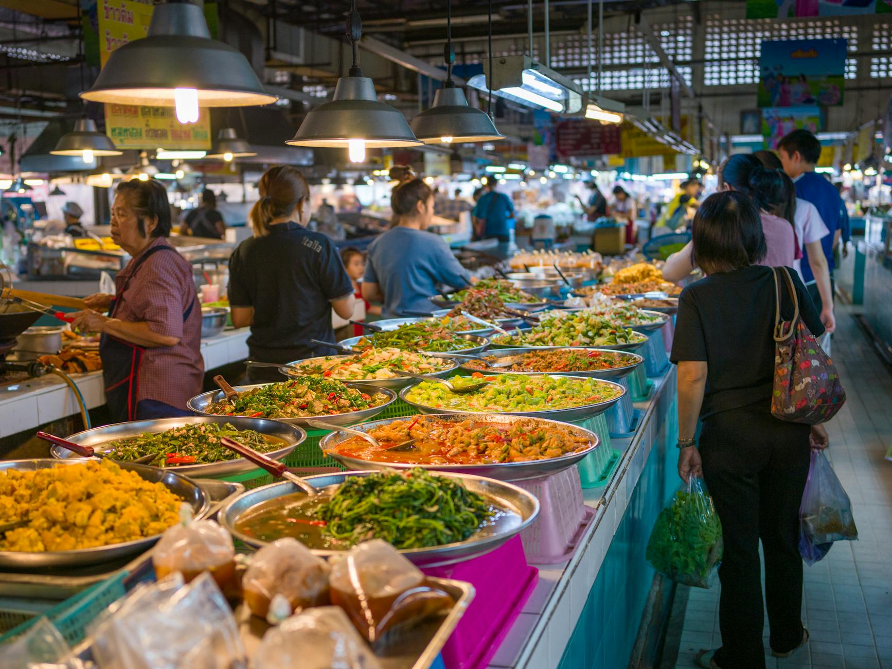 Kolorowe stragany z tajskim street foodem na gwarnym targu w Bangkoku
