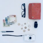 Portfel, banknoty i monety oraz gadżety na białym tle