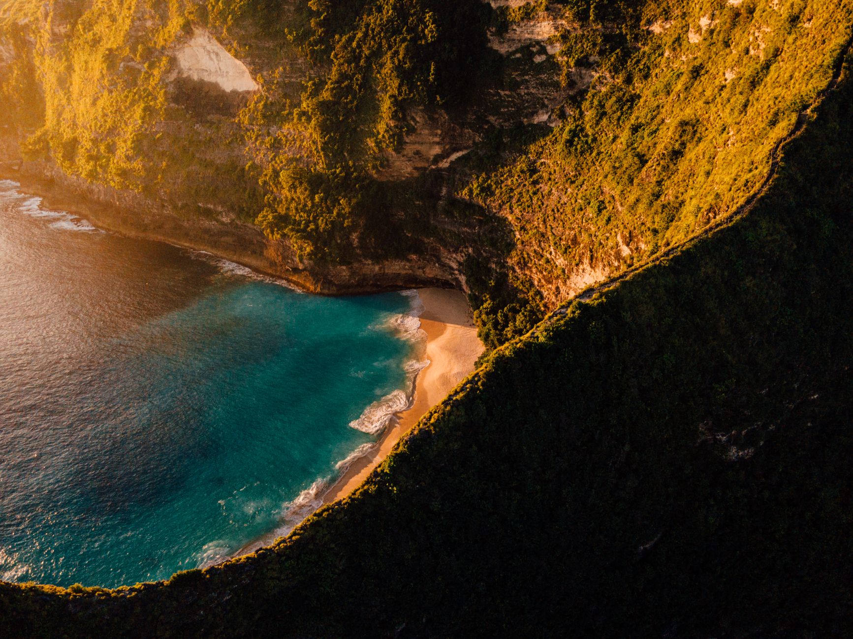 Klifowe wybrzeże Bali i turkusowa plaża o zachodzie słońca