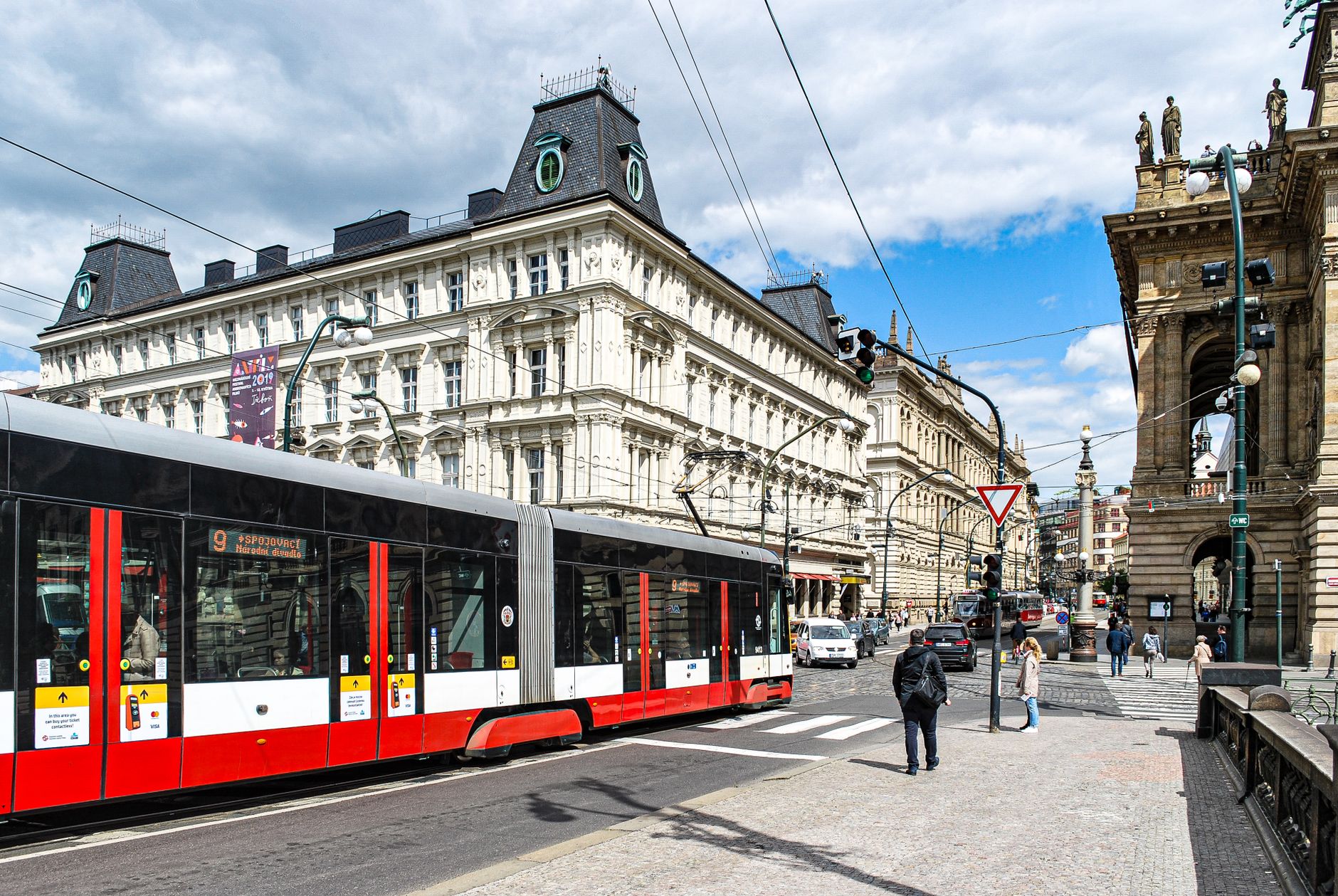 Nowoczesny tramwaj mijający zabytkowe kamienice w Pradze