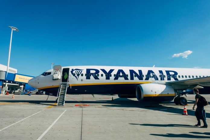 Samolot Ryanair przy schodach pokładowych na lotnisku pod błękitnym niebem Samolot Ryanair przy schodach pokładowych na lotnisku pod błękitnym niebem